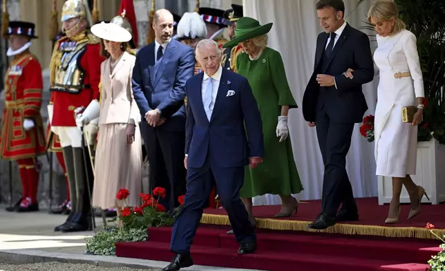 Britain's King Charles III, front, Queen Camilla, 3rd right, Prince William, 5th right, and Kate, Princess of Wales, left, walk with French President Emmanuel Macron, second right, and his wife Brigitte Macron, right, during a welcome ceremony, in Windsor, England, Tuesday July 8, 2025, on the first day of a three-day state visit to Britain. (Dylan Martinez/Pool via AP)