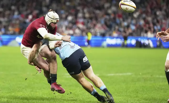 Mack Hansen of the British &amp; Irish Lions is tackled by a defender during the Lions and Waratahs rugby match in Sydney, Australia, Saturday, July 5, 2025. (AP Photo/Mark Baker)