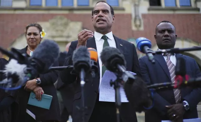 Ralph Regenvanu, center, Vanuatu's minister for climate change, speaks after the International Court of Justice's advisory opinion about nations' obligations to tackle climate change and consequences they may face if they don't, Wednesday, July 23, 2025, in The Hague, Netherlands. (AP Photo/Peter Dejong)