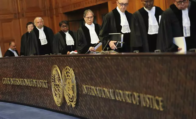 Presiding judge Yuji Iwasawa, fourth from right, enters the International Court of Justice ahead of an advisory opinion on what legal obligations nations have to address climate change and what consequences they may face if they don't, Wednesday, July 23, 2025, in The Hague, Netherlands. (AP Photo/Peter Dejong)