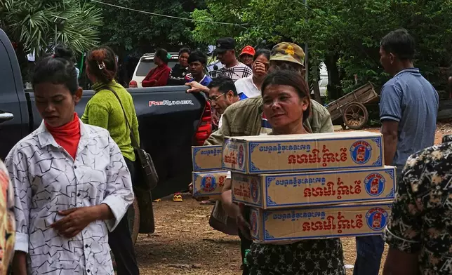 Local villagers carry boxes of Khmer noodle after they received the donated by a charity in Wat Phnom Kamboar, Oddar Meanchey province, Cambodia, Sunday, July 27, 2025, amid a deadly border dispute between Thailand and Cambodia. (AP Photo/Heng Sinith)