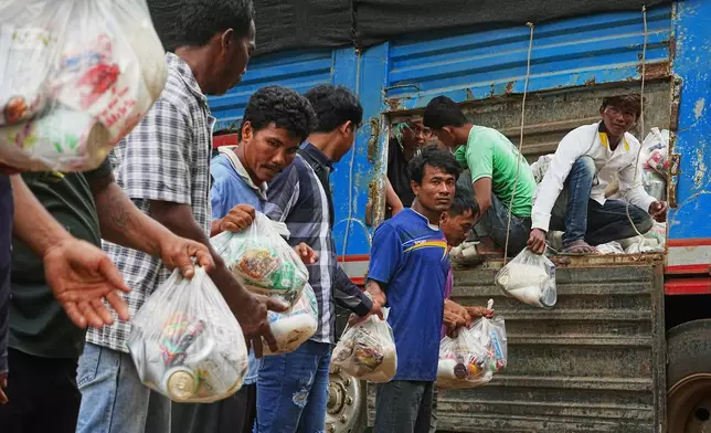 Local villagers help unloading supplies donated by a charity for refugees from a truck, as they take refuge in Wat Phnom Kamboar, Oddar Meanchey province, Cambodia, Sunday, July 27, 2025, amid the fighting between Thailand and Cambodia. (AP Photo/Heng Sinith)