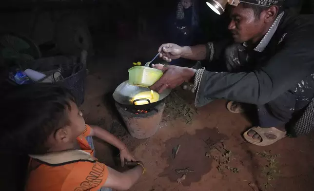 A Cambodian fries duck eggs at the Batploa primary school where he and others have taken refuge, in the Oddar Meanchey province, Cambodia, Thursday, July 24, 2025, as Thai and Cambodian soldiers clashed in several areas along their border in a major escalation of their conflict that left at several people dead, mostly civilians. (AP Photo/Heng Sinith)