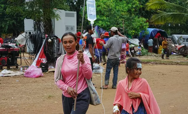 An evacuated child receives treatment helped by her mother in Wat Phnom Kamboar, Oddar Meanchey province, Cambodia, Sunday, July 27, 2025, as border fighting between Thailand and Cambodia entered its fourth day. (AP Photo/Heng Sinith)