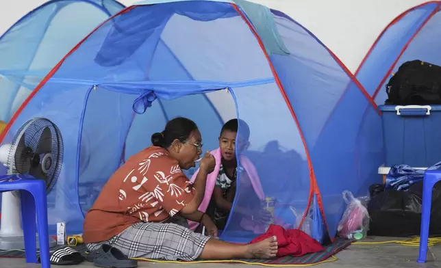 Thai residents who fled homes following clashes between Thai and Cambodian soldiers rest at an evacuation center in Surin province, Thailand, Sunday, July 27, 2025. (AP Photo/Sakchai Lalit)