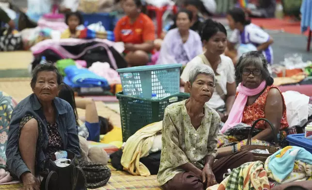 Thai residents who fled homes following clashes between Thai and Cambodian soldiers rest at an evacuation center in Surin province, Thailand, Friday, July 25, 2025. (AP Photo/Sakchai Lalit)