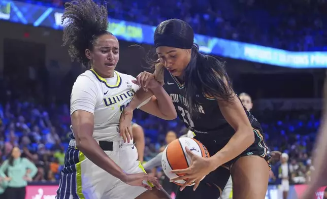 New York Liberty forward Isabelle Harrison (21) and Dallas Wings guard Haley Jones (30) reach for the ball during the first half of a WNBA basketball game in Arlington, Texas, Monday, July 28, 2025. (AP Photo/LM Otero)