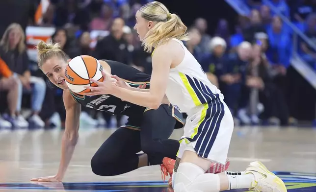Dallas Wings guard Paige Bueckers grabs the loose ball against New York Liberty guard Marine Johannes (23) during the first half of a WNBA basketball game in Arlington, Texas, Monday, July 28, 2025. (AP Photo/LM Otero)