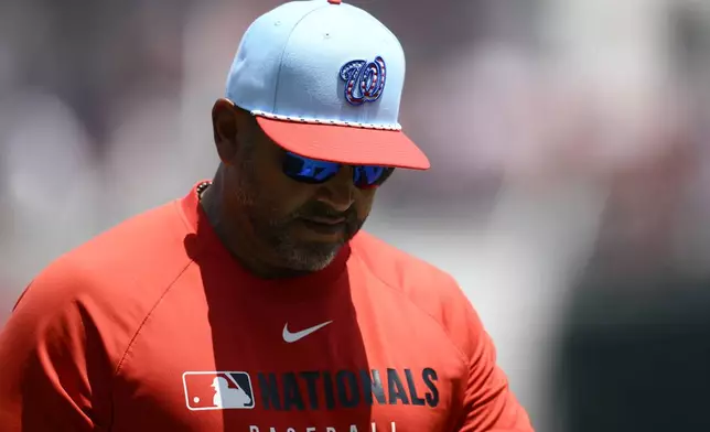 Washington Nationals manager Dave Martinez wears a patriotic themed cap as he walks back to the dugout after a pitching change during the fifth inning of a baseball game against the Boston Red Sox, Friday, July 4, 2025, in Washington. (AP Photo/Nick Wass)