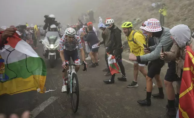 France's Lenny Martinez, wearing the best climber's dotted jersey, climbs Tourmalet pass in the fog during the fourteenth stage of the Tour de France cycling race over 182.6 kilometers (113.5 miles) with start in Pau and finish in Luchon Superbagneres, France, Saturday, July 19, 2025. (AP Photo/Thibault Camus)