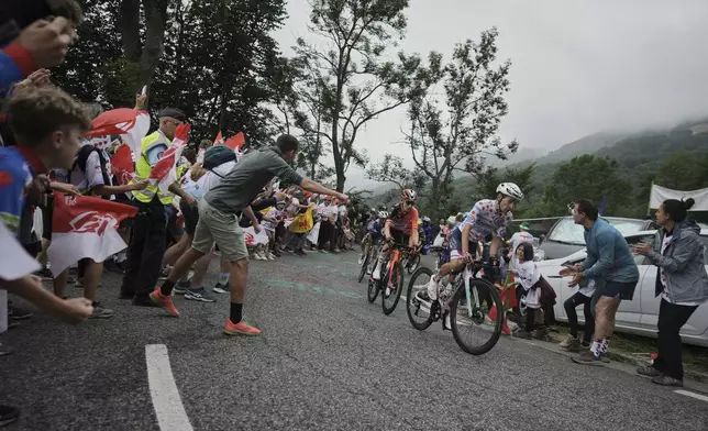 Stage winner Netherlands' Thymen Arensman, follows France's Lenny Martinez, wearing the best climber's dotted jersey, during the fourteenth stage of the Tour de France cycling race over 182.6 kilometers (113.5 miles) with start in Pau and finish in Luchon Superbagneres, France, Saturday, July 19, 2025. (AP Photo/Thibault Camus)