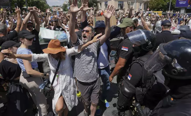 Serbian gendarmerie officers remove a street blockade that was set up as part of a protest over a spate of arrests of anti-government protesters after a massive rally demanding an early parliamentary election in Belgrade, Serbia, Monday, June 30, 2025. (AP Photo/Darko Vojinovic)
