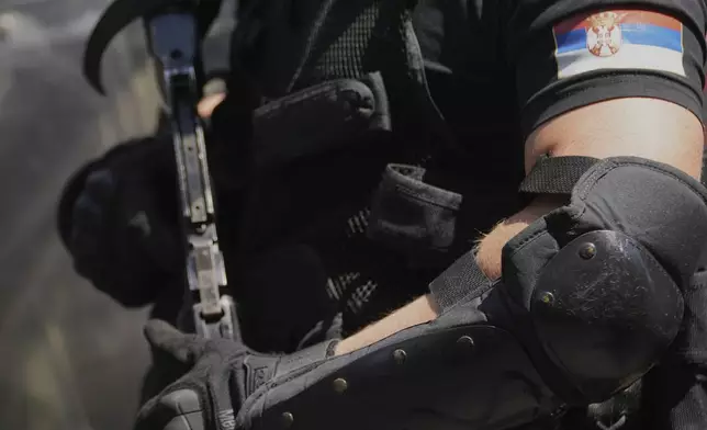 Serbian gendarmerie officers prepare to remove a street blockade that was set up as part of a protest over a spate of arrests of anti-government protesters after a massive rally demanding an early parliamentary election in Belgrade, Serbia, Monday, June 30, 2025. (AP Photo/Darko Vojinovic)
