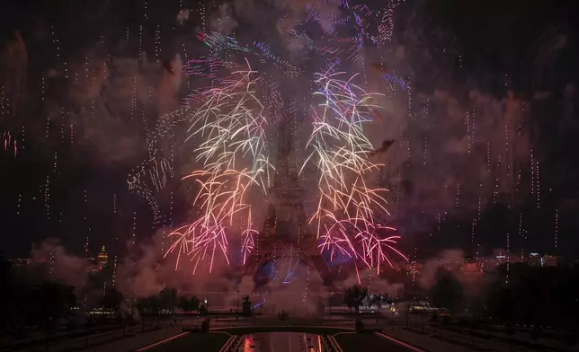 Fireworks and drones illuminate the Eiffel Tower in Paris during Bastille Day celebrations late Monday, July 14, 2025. (AP Photo/Aurelien Morissard)