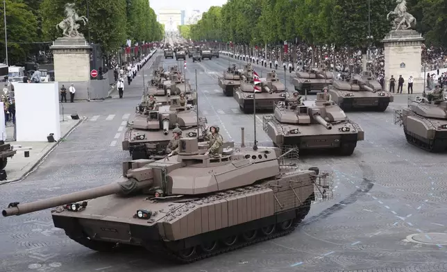 Leclerc tanks drive down the Champs-Elysees avenue during the Bastille Day parade, Monday, July 14, 2025 in Paris. (AP Photo/Christophe Ena)