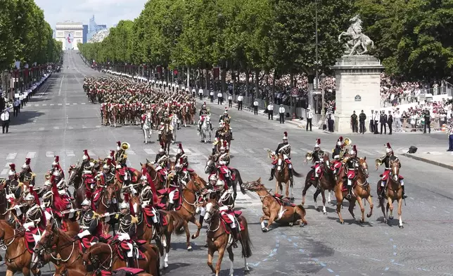 A horse slides on the pavement during the Bastille Day parade, Monday, July 14, 2025 in Paris. (AP Photo/Christophe Ena)