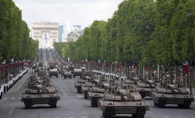 Leclerc tanks drive down the Champs-Elysees avenue during the Bastille Day parade, Monday, July 14, 2025 in Paris. (AP Photo/Christophe Ena)