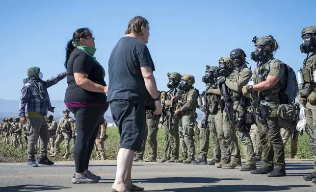 Protesters standoff against federal immigration agents during a raid in the agriculture area of Camarillo, Calif., Thursday, July 10, 2025. (AP Photo/Michael Owen Baker)