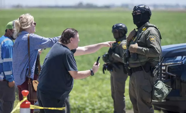 People shout at federal immigration agents during a raid in the agriculture area of Camarillo, Calif., July 10, 2025. (AP Photo/Michael Owen Baker)