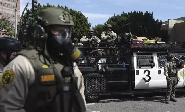 FILE - Law enforcement officers stand guard during a protest June 14, 2025, in Los Angeles. (AP Photo/Ethan Swope, File)