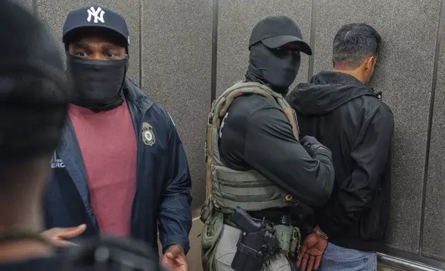 FILE - Immigration and Customs Enforcement agents escort a detained immigrant into an elevator after he exited an immigration courtroom, Tuesday, June 17, 2025, in New York. (AP Photo/Olga Fedorova, file)