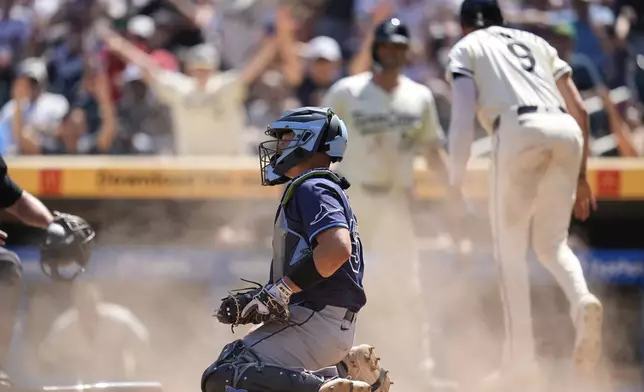 CORRECTS TO RAYS SECOND BASEMAN JOSE CABALLERO NOT JUNIOR CAMINERO - Tampa Bay Rays catcher Matt Thaiss, center, sits by home plate after Minnesota Twins' Trevor Larnach (9) scored off an error by Rays second baseman José Caballero (not shown) during the sixth inning of a baseball game Sunday, July 6, 2025, in Minneapolis. (AP Photo/Abbie Parr)