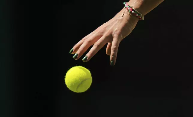 Aryna Sabalenka of Belarus plays with the ball during her match against Carson Branstine of Canada at their first round women's single match at the Wimbledon Tennis Championships in London, Monday, June 30, 2025. (AP Photo/Kin Cheung)