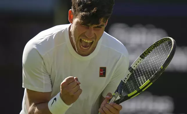 Carlos Alcaraz of Spain reacts after winning the third set against Fabio Fognini of Italy during their first round men's singles match at the Wimbledon Tennis Championships in London, Monday, June 30, 2025. (AP Photo/Alastair Grant)