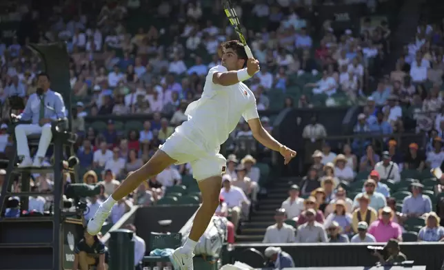 Carlos Alcaraz of Spain returns to Fabio Fognini of Italy during their first round men's singles match at the Wimbledon Tennis Championships in London, Monday, June 30, 2025. (AP Photo/Alastair Grant)