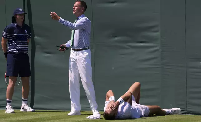 Hamad Medjedovic of Serbia lies injured on the court after he ran into a board during his first round men's singles match against Sebastian Ofner of Austria at the Wimbledon Tennis Championships in London, Tuesday, July 1, 2025.(AP Photo/Dave Shopland)