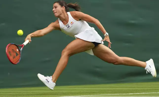 Emma Navarro of the U.S. returns the ball to Petra Kvitova of Czech Republic during their first round women's single match at the Wimbledon Tennis Championships in London, Tuesday, July 1, 2025.(AP Photo/Kirsty Wigglesworth)