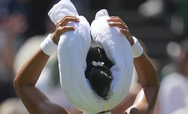 Alexandra Eala of the Philippines tries to keep cool as she plays Barbora Krejcikova of Czech Republic during their first round women's singles match at the Wimbledon Tennis Championships in London, Tuesday, July 1, 2025. (AP Photo/Kin Cheung)