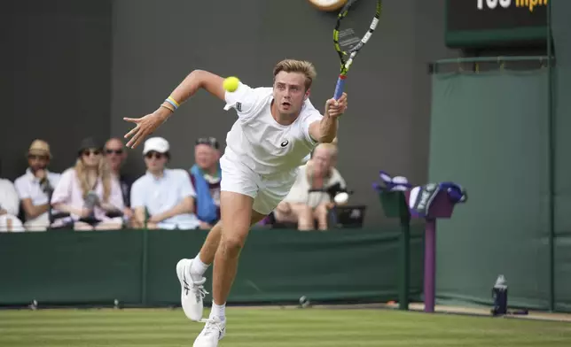 Johannus Monday of Britain returns to Tommy Paul of the U.S. during their first round men's singles match at the Wimbledon Tennis Championships in London, Tuesday, July 1, 2025. (AP Photo/Alastair Grant)