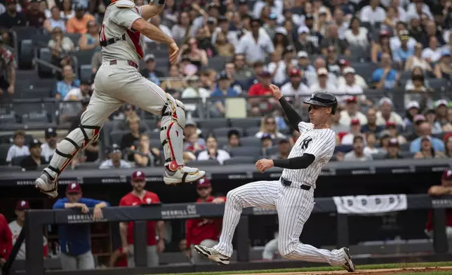 New York Yankees' Cody Bellinger, right, is about to be out at home plate against Philadelphia Phillies catcher J.T. Realmuto, left, during the third inning of a baseball game, Sunday, July 27, 2025, in New York. (AP Photo/Angelina Katsanis)