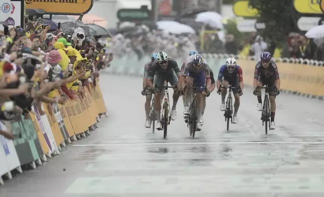 Italy's Jonathan Milan, left, crosses the finish line ahead of Belgium's Jordi Meeus to win the seventeenth stage of the Tour de France cycling race over 160.4 kilometers (99.7 miles) with start in Bollene and finish in Valence, France, Wednesday, July 23, 2025. (AP Photo/Thibault Camus)