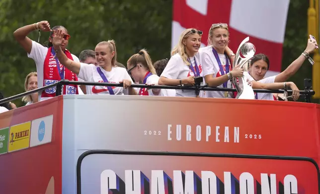 England's soccer players celebrate with fans during an open-top bus procession and ceremony in central London, Tuesday, July 29, 2025 after their victory in the Women's EURO 2025 final.(AP Photo/Joanna Chan)