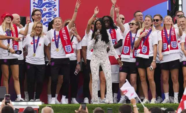 England's soccer head coach Sarina Wiegman, 2nd left and the players sing along with artist Heather Small, center, during a homecoming victory parade and celebration outside Buckingham Palace in London, after winning the Women's Euro 2025,Tuesday, July 29, 2025.(AP Photo/Kirsty Wigglesworth)