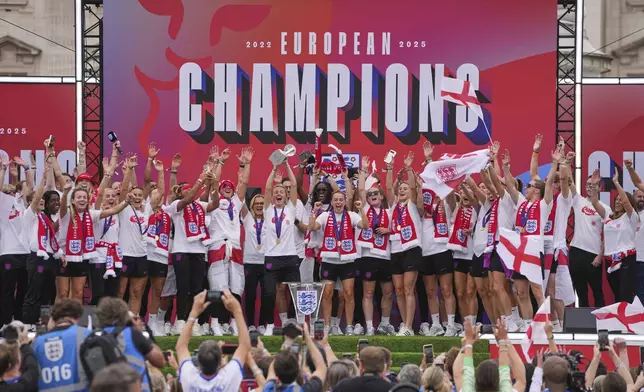 England's soccer players celebrate with fans during a ceremony on a stage in front of Buckingham Palace in central London, Tuesday, July 29, 2025 after their victory in the Women's EURO 2025 final.(AP Photo/Kin Cheung)