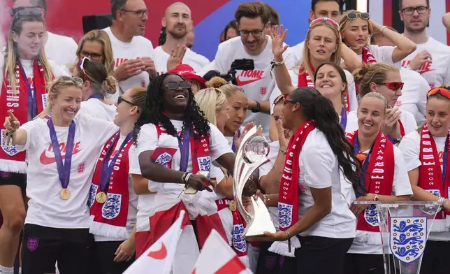 England's soccer player Michelle Agyemang, center, and goalkeeper Khiara Keating hold the trophy during a homecoming victory parade and celebration outside Buckingham Palace in London, after winning the Women's Euro 2025,Tuesday, July 29, 2025.(AP Photo/Kirsty Wigglesworth)