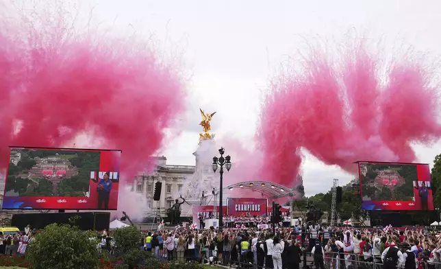 England's soccer players on a stage celebrate with thousands of fans during a homecoming victory parade and celebration outside Buckingham Palace in London, after winning the Women's Euro 2025,Tuesday, July 29, 2025.(AP Photo/Kirsty Wigglesworth)