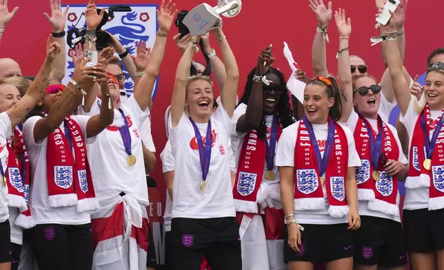England's soccer team captain Leah Williamson lifts the trophy with her teammates on a stage celebrating with thousands of fans during a homecoming victory parade and celebration outside Buckingham Palace in London, after winning the Women's Euro 2025,Tuesday, July 29, 2025.(AP Photo/Kirsty Wigglesworth)