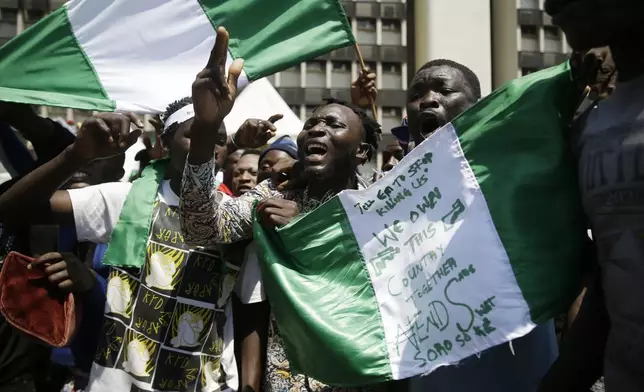 FILE- People hold banners as they demonstrate on the street to protest against police brutality, in Lagos, Nigeria, Tuesday, Oct 20, 2020. (AP Photo/Sunday Alamba, File)