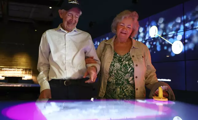 Mario and Gail Cirasunda, of Orchard Park, N.Y., interact with one of the museum's touch screen exhibits during a Memory Cafe event at the National Comedy Center Monday, May 5, 2025, in Jamestown, N.Y. (AP Photo/Jeffrey T. Barnes)