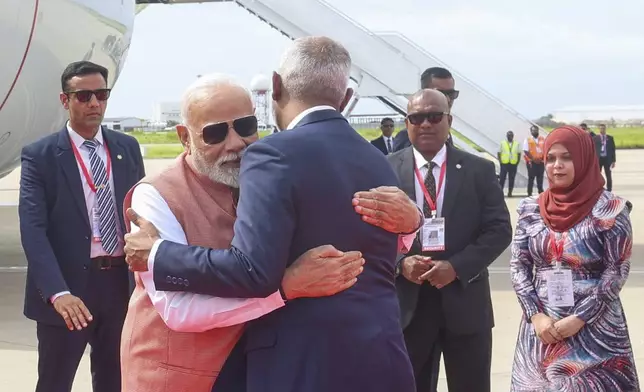 Indian Prime Minister Narendra Modi, and Maldives President Mohamed Muizzu, back to camera hug each other upon Modi's arrival at the airport, in Male, Maldives, Friday, July 25, 2025. (Indian Prime Ministers Office via AP)