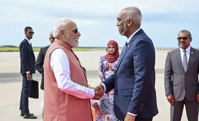 In this photo provided by the Maldivian President's Office, Indian Prime Minister Narendra Modi shakes hands with Maldivian president Mohamed Muizzu after his arrival in Male, Maldives, Friday, July 25, 2025.(Maldivian President's Office via AP)