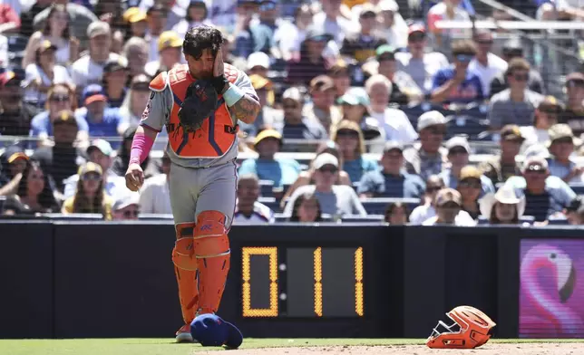 New York Mets catcher Francisco Alvarez reacts after taking a foul ball off his mask hit by San Diego Padres' Martin Maldonado in the fifth inning of a baseball game Wednesday, July 30, 2025, in San Diego. (AP Photo/Derrick Tuskan)