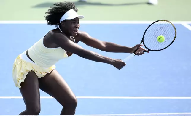 Venus Williams reaches for the ball during a doubles match with Hailey Baptiste against Eugenie Bouchard and Clervie Ngounoue at the Citi Open tennis tournament Monday, July 21, 2025, in Washington. (AP Photo/Nick Wass)