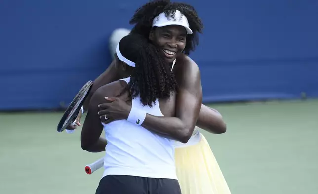 Venus Williams, right, hugs her doubles partner Hailey Baptiste, left, after they defeated Eugenie Bouchard and Clervie Ngounoue in a doubles match at the Citi Open tennis tournament Monday, July 21, 2025, in Washington. (AP Photo/Nick Wass)