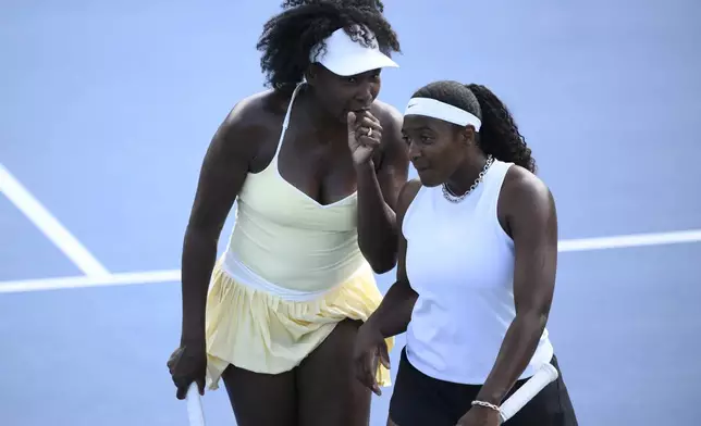 Venus Williams, left, talks with Hailey Baptiste, right, during a doubles match against Eugenie Bouchard and Clervie Ngounoue at the Citi Open tennis tournament Monday, July 21, 2025, in Washington. (AP Photo/Nick Wass)