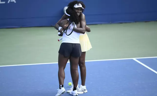 Venus Williams, right, hugs her doubles partner Hailey Baptiste, left, after they defeated Eugenie Bouchard and Clervie Ngounoue in a doubles match at the Citi Open tennis tournament Monday, July 21, 2025, in Washington. (AP Photo/Nick Wass)